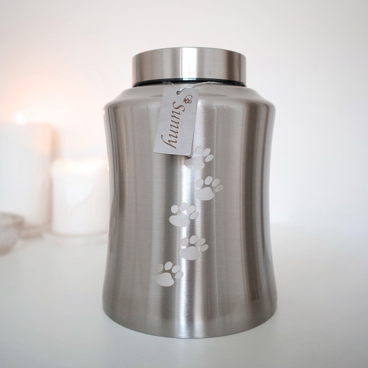 Traditional brushed metal pet urn personalised with pet name on dog tag, embossed with paw prints