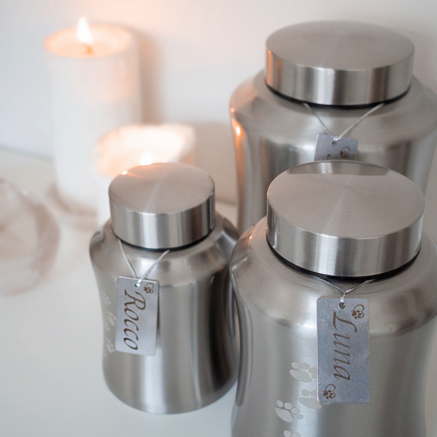 Traditional brushed metal pet urn personalised with pet name on dog tag, embossed with paw prints