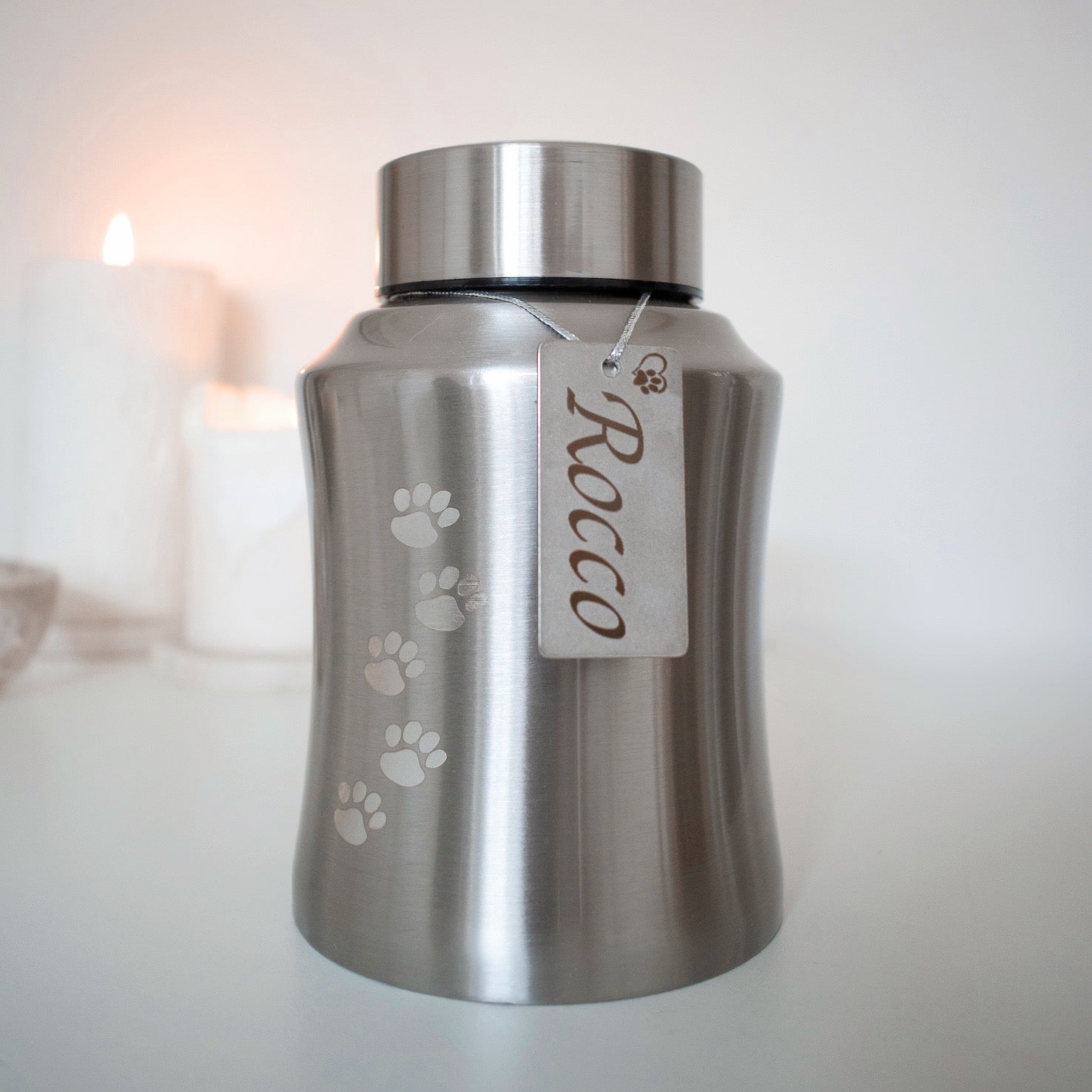 Traditional brushed metal pet urn personalised with pet name on dog tag, embossed with paw prints